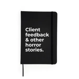 Agendă neagră cu mesaj „Client feedback & other horror stories.”
